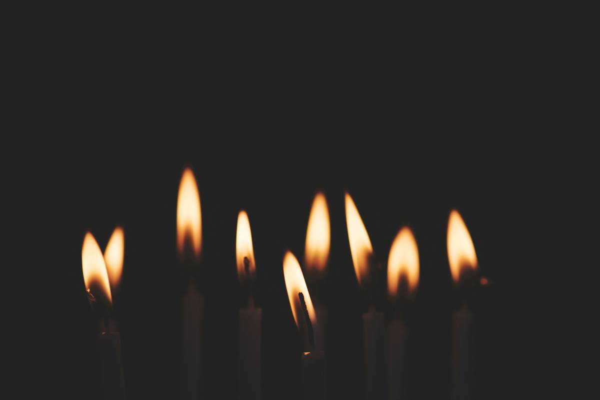 Close-up of burning candles for home scented with visible melt pool and wooden wick glowing softly
